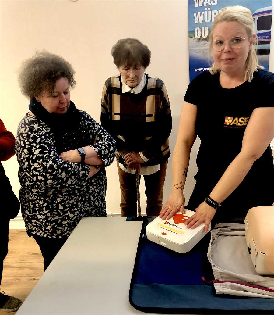 Ina Brandes demonstriert die Arbeit mit dem AED-Gerät